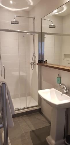 une salle de bain avec une douche et un lavabo et une douche dans l'établissement Stanhill Court Hotel, a member of Radisson Individuals, à Charlwood
