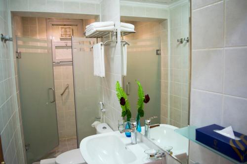 a bathroom with a sink and a toilet and a mirror at The Royal Express Sharq in Kuwait