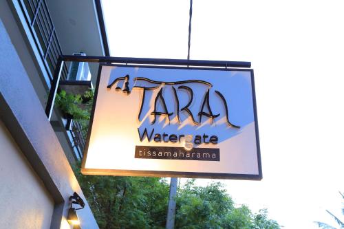 a sign hanging from the side of a building at Tara Watergate in Tissamaharama