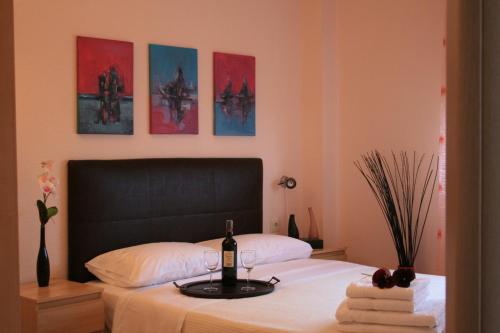 a bedroom with a bed with a bottle of wine on it at Yasoo Holiday Apartments in Olympiada