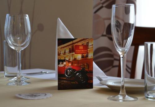 a table with two wine glasses and a card on it at Hotel Havel in Rychnov nad Kněžnou