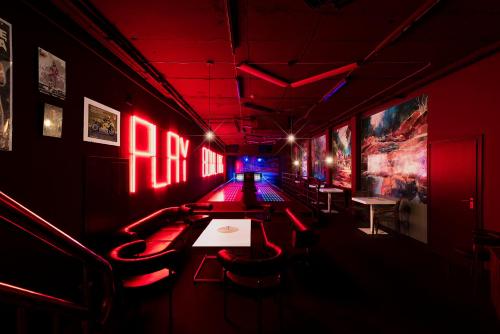 a room with red lights and tables and chairs at Hotel Mazurski Raj in Ruciane-Nida