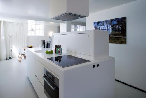 a white kitchen with a sink and a stove at Urban Residences Maastricht in Maastricht