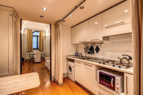 una cucina con lavandino e piano cottura forno superiore di Magenta Collection Specchi a Roma