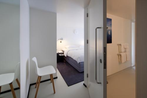 a bedroom with a bed and a table and a chair at Urban Residences Maastricht in Maastricht