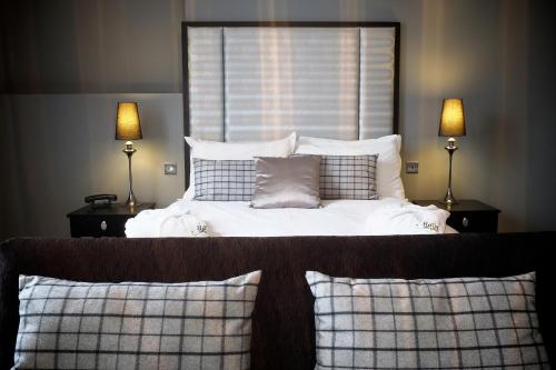 a bed with white sheets and pillows in a bedroom at Poets House in Ely