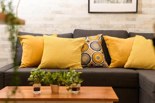 a couch with yellow pillows and a coffee table at Suiren Residential Suite Tokyo in Tokyo