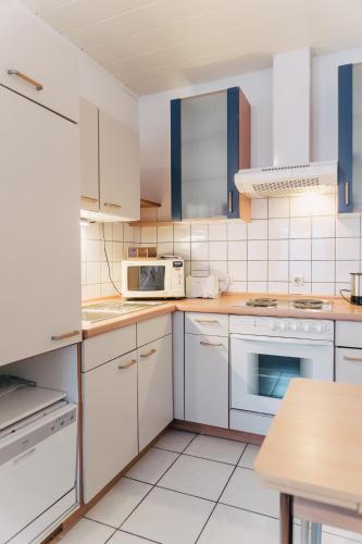 a kitchen with white cabinets and white appliances at Apartment in Innenstadtnähe in Darmstadt