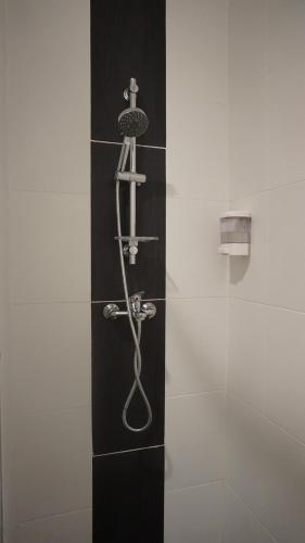 a shower with a hose on a glass wall at Bernard Holiday Home 2 @ Boulevard Imperial Suite Kuching in Kuching