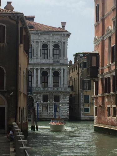 a boat in a canal in front of a building at TINTORETTO 1 CON TERRAZZA SOPRA IL TETTO, 3 bagni, 3 grandi camere da letto, SUPER NUOVO in Venice
