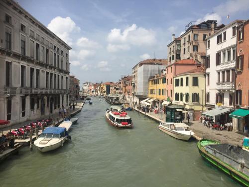 two boats in a canal in a city with buildings at TINTORETTO 1 CON TERRAZZA SOPRA IL TETTO, 3 bagni, 3 grandi camere da letto, SUPER NUOVO in Venice