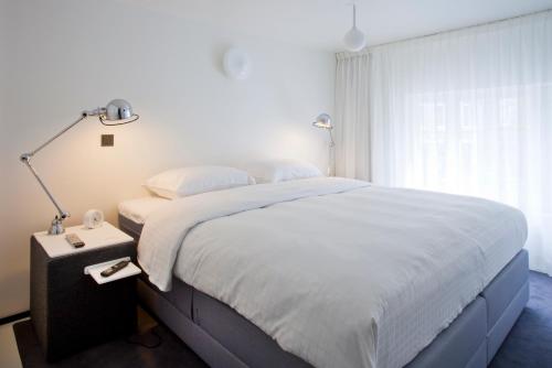 a bedroom with a large bed and a window at Urban Residences Maastricht in Maastricht