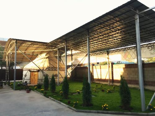 a large building with a grass yard in front of it at Apple Hostel Bishkek in Bishkek