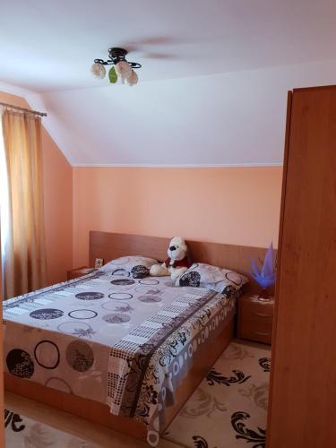 een teddybeer op een bed in een slaapkamer bij Steluța in Călimăneşti
