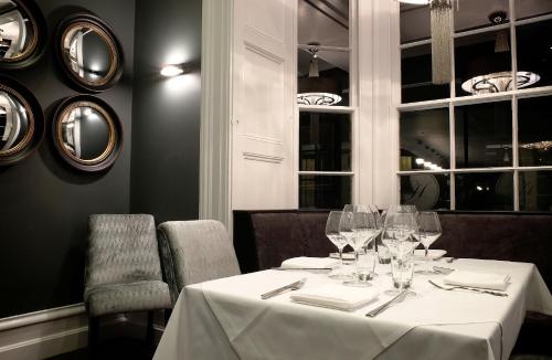 a dining room with a table with wine glasses at Poets House in Ely
