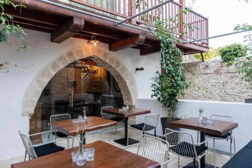 a restaurant with tables and chairs and a staircase at Oinou Strata - Adults Only in Vouni