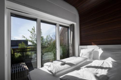a bedroom with two beds and a large window at Steel House Copenhagen in Copenhagen