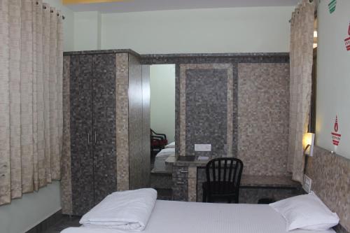 a bedroom with a bed and a table with a chair at Hotel Kwality Inn in Satna