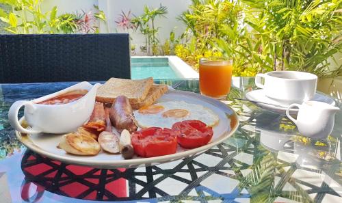 un plato de comida con pan y tomates en una mesa en Karon Pool Hotel, en Karon Beach