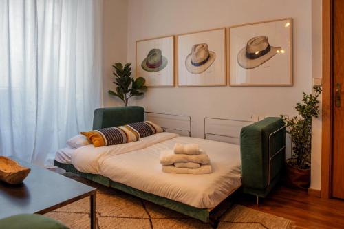 un soggiorno con 2 letti e cappelli appesi al muro di Apartamento moderno junto a la Gran Via a Madrid