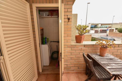 a door to a patio with a table and a window at Dunas Flat in Lavra