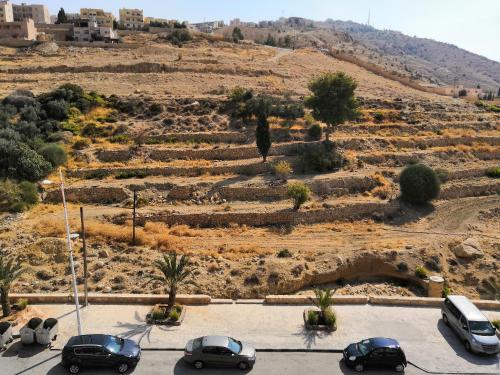 a parking lot with cars parked in front of a hill at Sunset Hotel in Wadi Musa