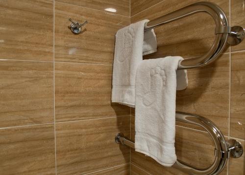 a bathroom with white towels hanging on a wall at Hotel Milot in Volzhskiy