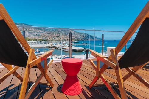 
a row of chairs sitting on top of a wooden deck at Pestana CR7 Funchal in Funchal
