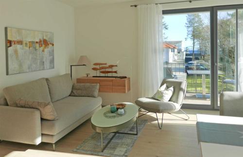 バーベにあるBaabe Villa Andrea Ferienwohnung Mのリビングルーム(ソファ、テーブル、椅子付)