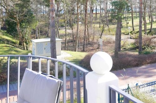 a white chair sitting on a railing on a porch at Baabe Villa Andrea Ferienwohnung M in Baabe