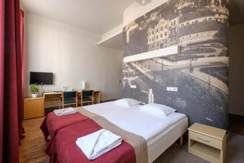 a hotel room with two beds and a wall mural at Hotel Metropolis in Kaunas