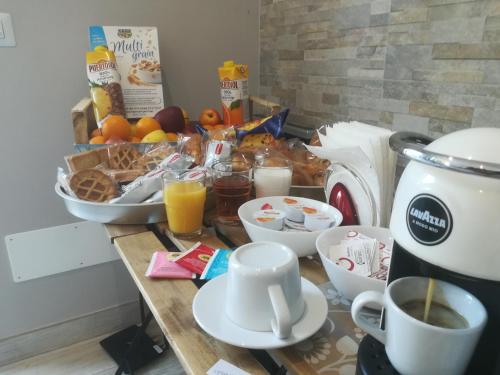 a table with breakfast foods and coffee on it at B&B Purple Italy in Fiumicino