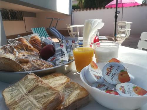 a table with a tray of bread and a bowl of juice at B&B Purple Italy in Fiumicino