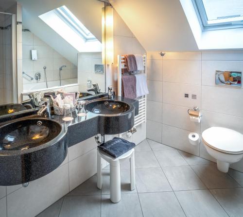 ein Badezimmer mit zwei Waschbecken und einem WC in der Unterkunft Hotel Passauer Wolf in Passau