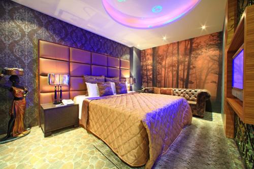 sypialnia z dużym łóżkiem i telewizorem w obiekcie Rainbow Forest Motel w mieście Xiushui