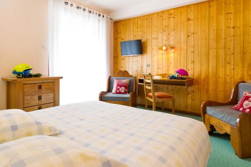 une chambre d'hôtel avec un lit, un bureau et une table dans l'établissement Hôtel Les Soldanelles, à La Toussuire