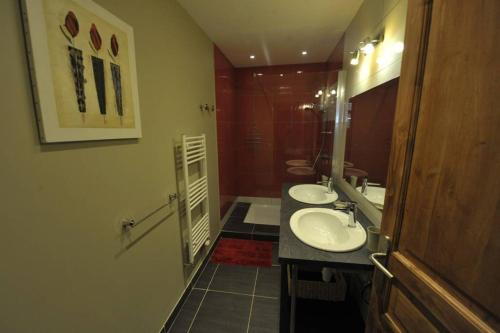 a bathroom with two sinks and a shower at Appartement Grande terrasse in La Bourboule