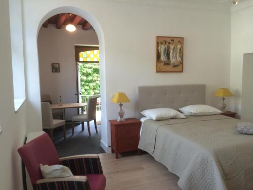 デュルビュイにあるLes Roques Apartments in historical Monasteryのベッドルーム1室(ベッド1台付)、ダイニングルーム(テーブル付)