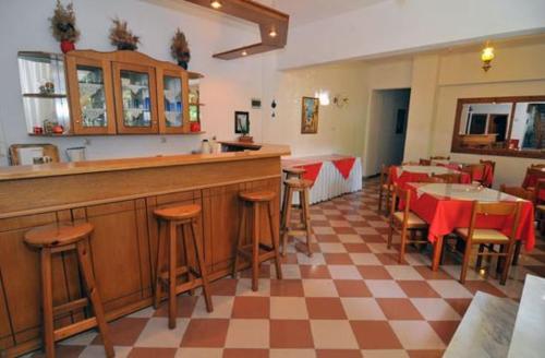 a restaurant with a bar and some tables and chairs at Chrissafis Hotel in Panagia
