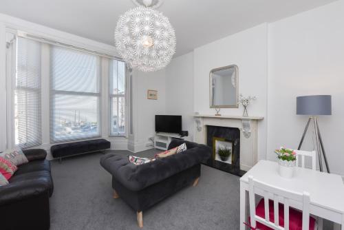 a living room with a couch and a chandelier at Spacious one bedroom apartment with a sofa bed offering a sea view sleeps four in Broadstairs