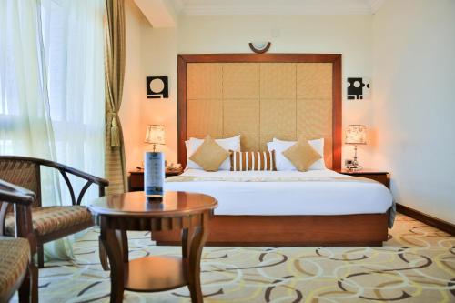 1 dormitorio con 1 cama, 1 mesa y 1 silla en Swiss Inn Nexus Hotel, en Addis Ababa