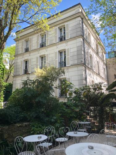 un bâtiment avec des tables et des chaises devant lui dans l'établissement Hôtel Particulier Montmartre, à Paris