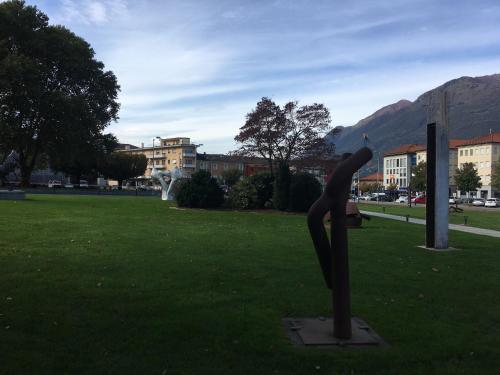 a statue of a person sitting on a bench in a field at Hotel San Giobbe in Giubiasco