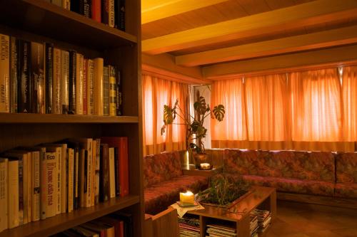 sala de estar con sofá, mesa y libros en Albergo Bellaria, en Carano
