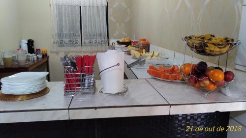 - un comptoir de cuisine avec des assiettes et des fruits dans l'établissement Pousada Aconchego, à Mateiros