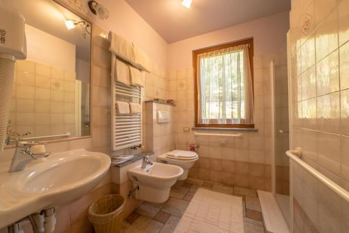uma casa de banho branca com um lavatório e um WC em Hotel Lo Fleyé em Saint-Pierre