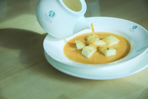 a bowl of soup with a cup of coffee at Swiss Inn Nexus Hotel in Addis Ababa