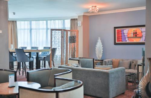 a living room with a couch and chairs and a table at Swiss Inn Nexus Hotel in Addis Ababa