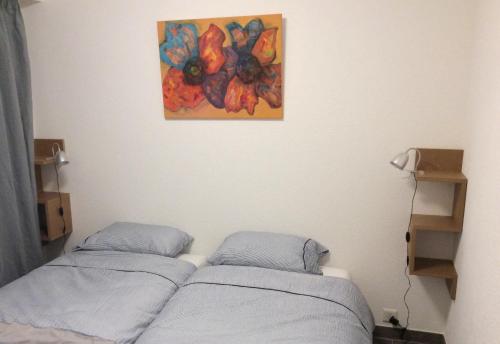 2 Betten in einem Zimmer mit Wandgemälde in der Unterkunft Le Président 2 in Sierre