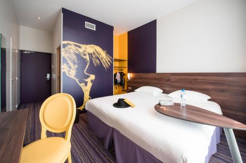 a hotel room with a large bed with a wooden headboard at ibis Styles Saumur Gare Centre in Saumur